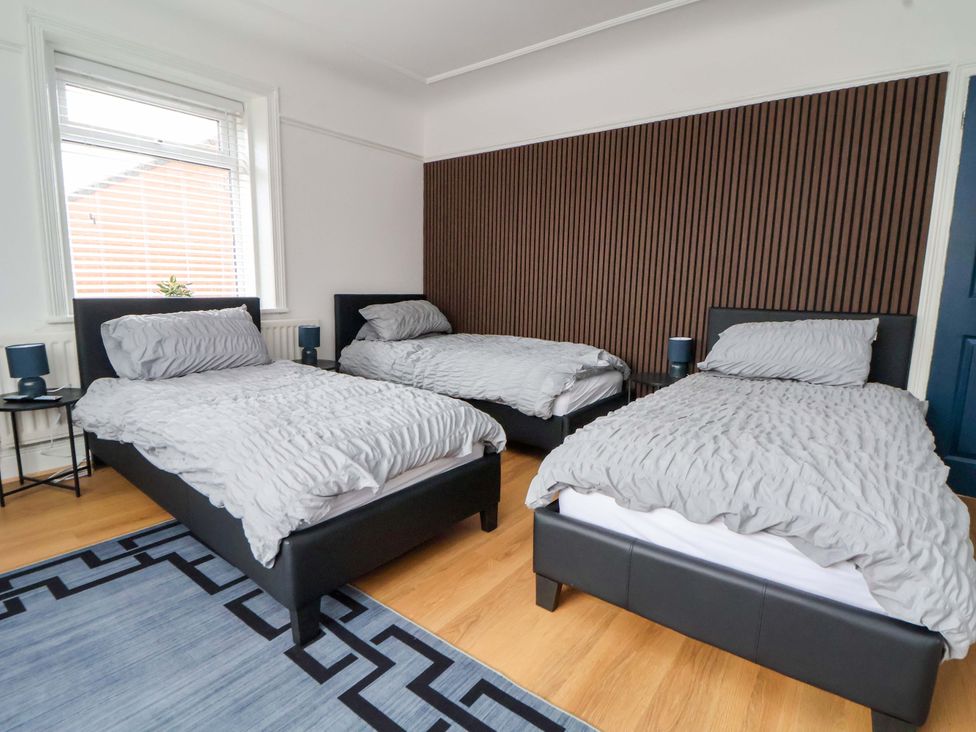 A bedroom with three beds and a window at Wallasey Village Escape by the Sea
