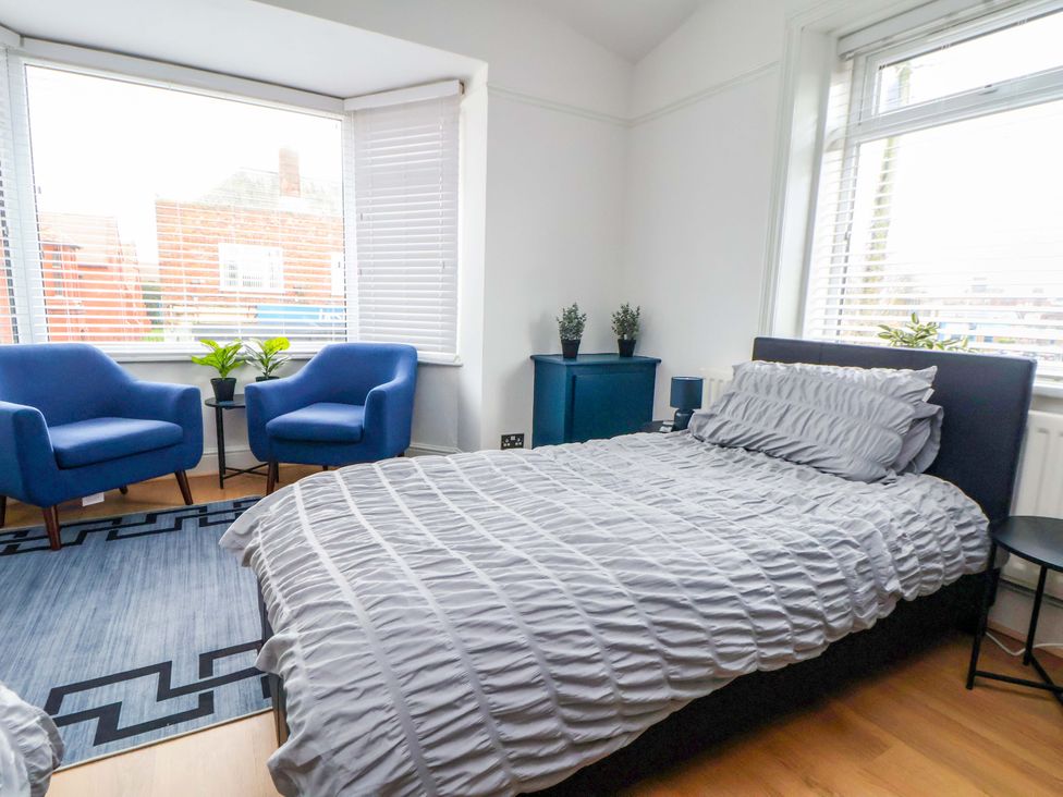 A bedroom with a bed and two chairs at Wallasey Village Escape by the Sea, Wallasey