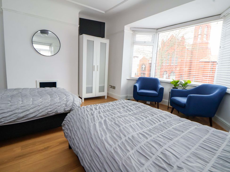 A bedroom with two beds and two armchairs at Wallasey Village Escape by the Sea in Wallasey