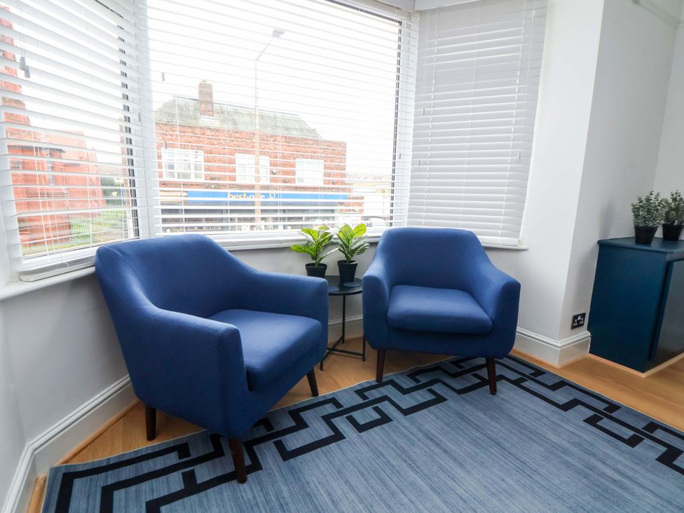 Two blue armchairs and a plant in a living room at Wallasey Village Escape by the Sea in Wallasey