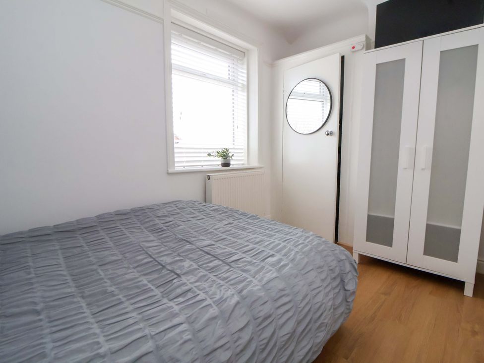 A bedroom with a bed and a wardrobe at Wallasey Village Escape by the Sea in Wallasey