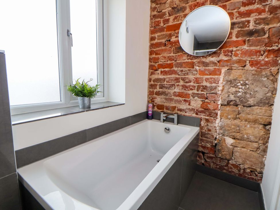 A bathroom with a bathtub and a mirror at Wallasey Village Escape by the Sea in Wallasey