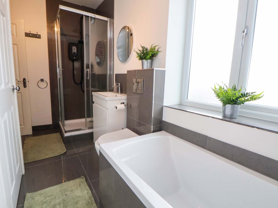 A bathroom with a shower, bathtub, and sink at Wallasey Village Escape by the Sea in Wallasey