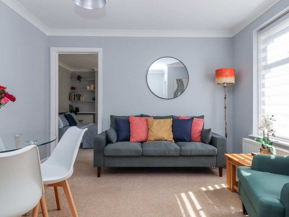 A living room with a sofa and dining table at The Arches in Torquay