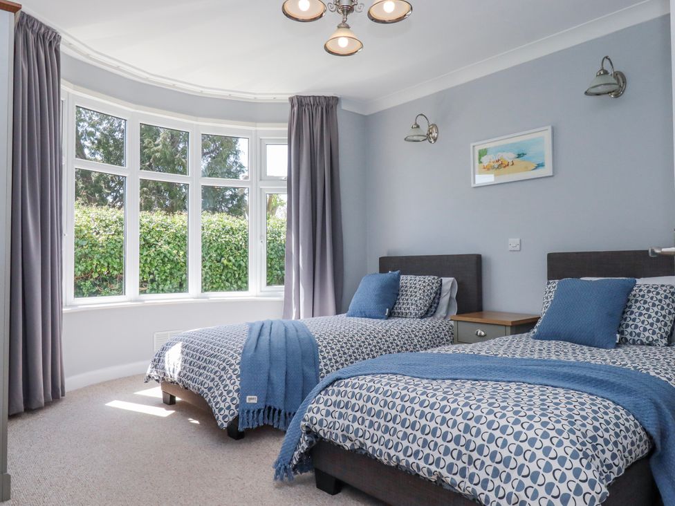 A bedroom with two beds and a nightstand at The Arches in Torquay