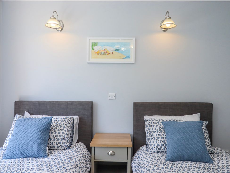 A bedroom with two beds and a nightstand at The Arches in Torquay