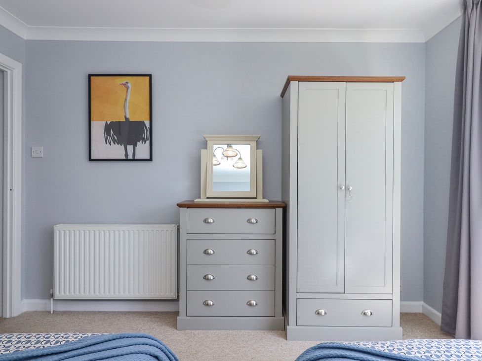A bedroom with a wardrobe and chest of drawers at The Arches in Torquay