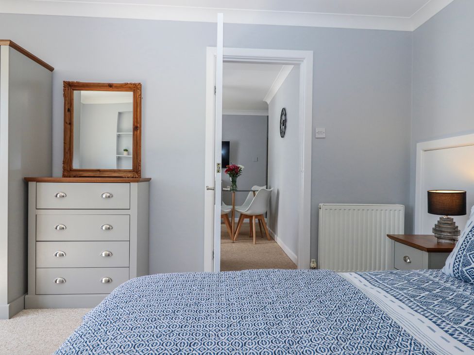 A bedroom with a dresser and a mirror at The Arches in Torquay