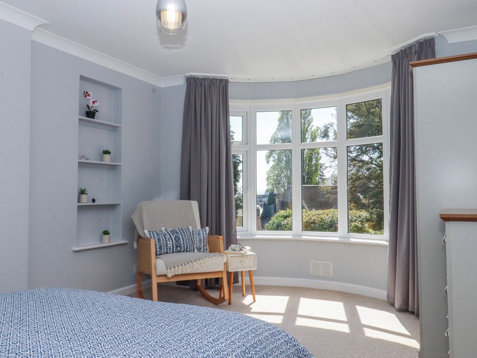 A bedroom with a window and chair at The Arches in Torquay
