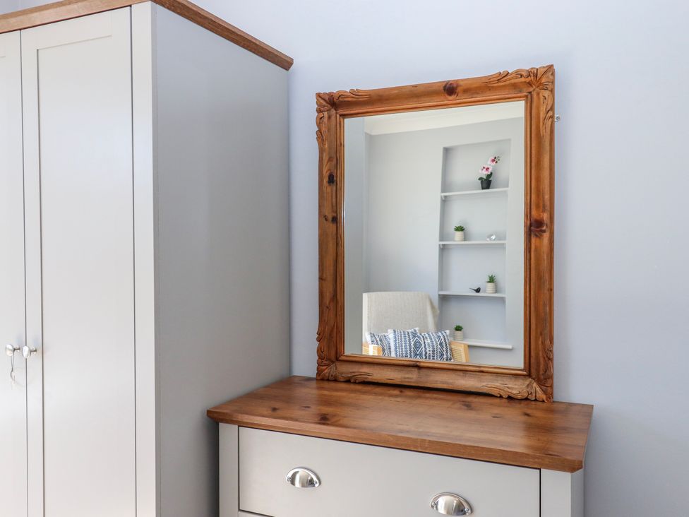 A bedroom with a mirror and wardrobe at The Arches in Torquay