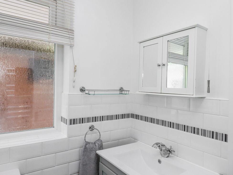 A bathroom with a sink and mirror cabinet at The Arches in Torquay