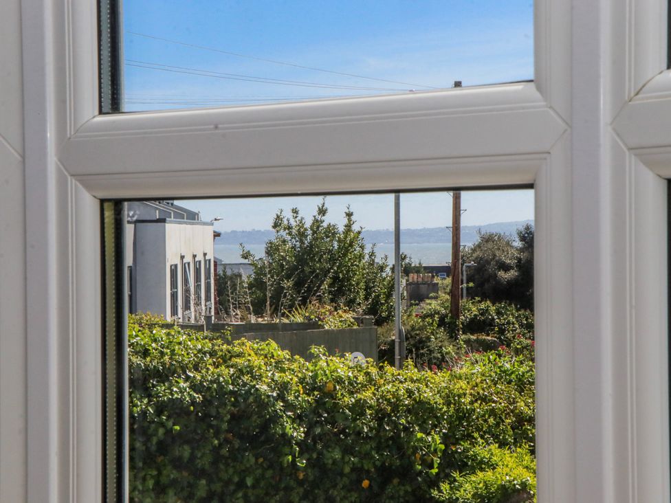 A view from a window showing greenery and buildings at The Arches in Torquay