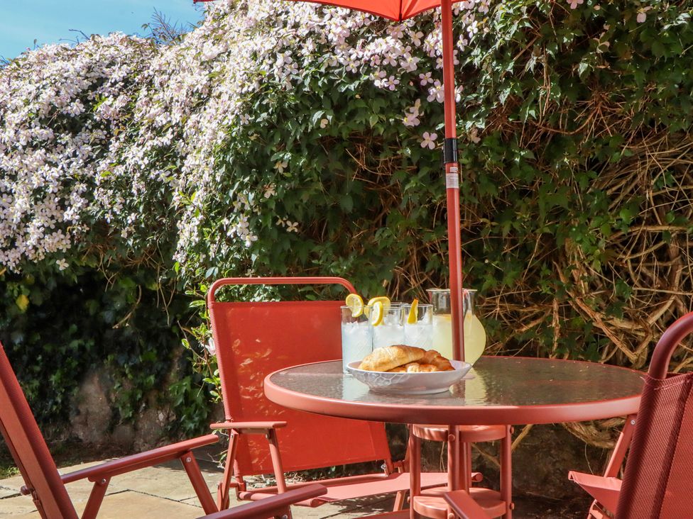 An outdoor seating area with a table and chairs at The Arches in Torquay