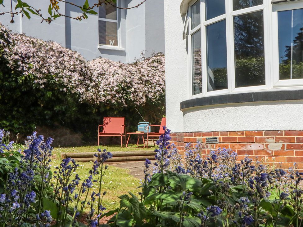 A garden with chairs and flowers at The Arches in Torquay