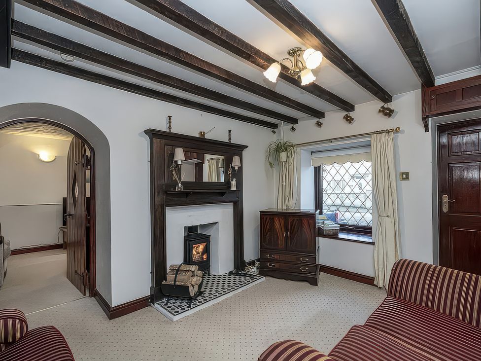 A living room with a fireplace and mirror at Preswylfa
