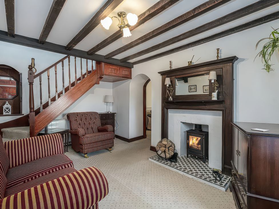 A living room with a stair and fireplace at Preswylfa