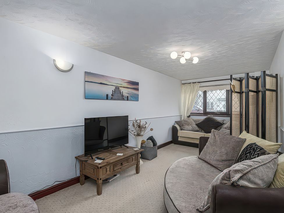 A living room with a television and a coffee table at Preswylfa