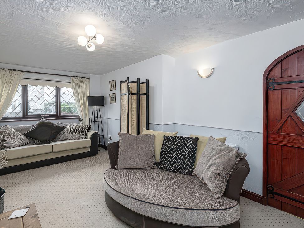 A living room with sofa and armchair at Preswylfa