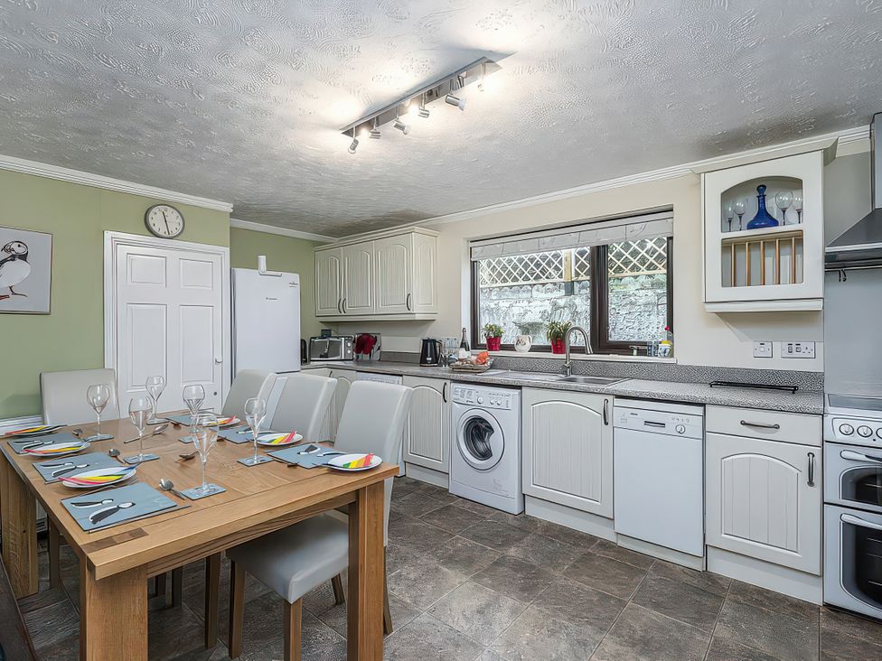 A kitchen with table and chairs at Preswylfa