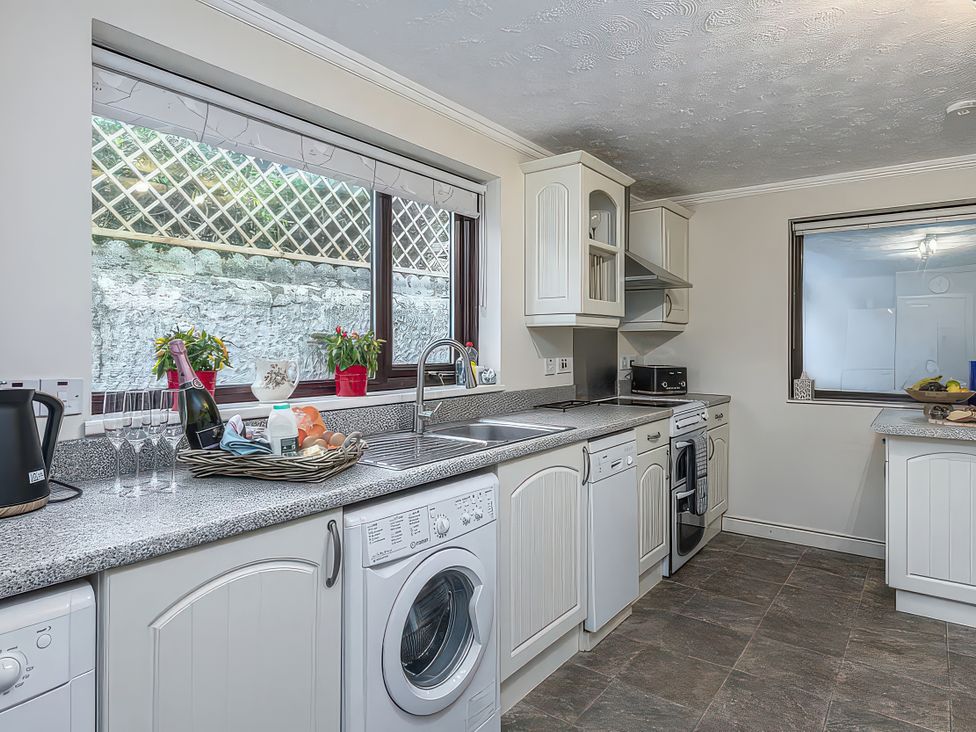 A kitchen with a sink and appliances at Preswylfa