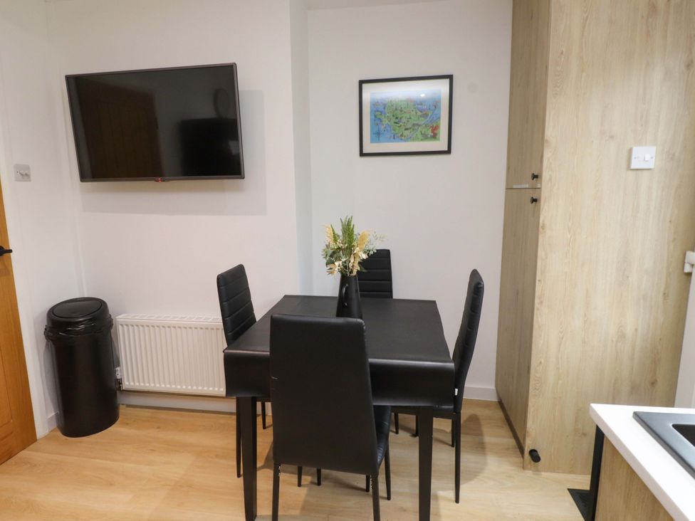 A dining room with a table and chairs at Y Byngalo, Trearddur Bay