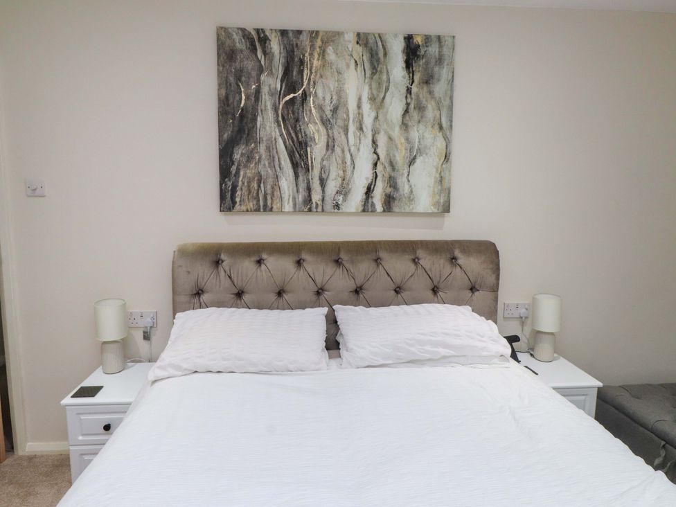 A bedroom with a bed and side tables at Y Byngalo in Trearddur Bay