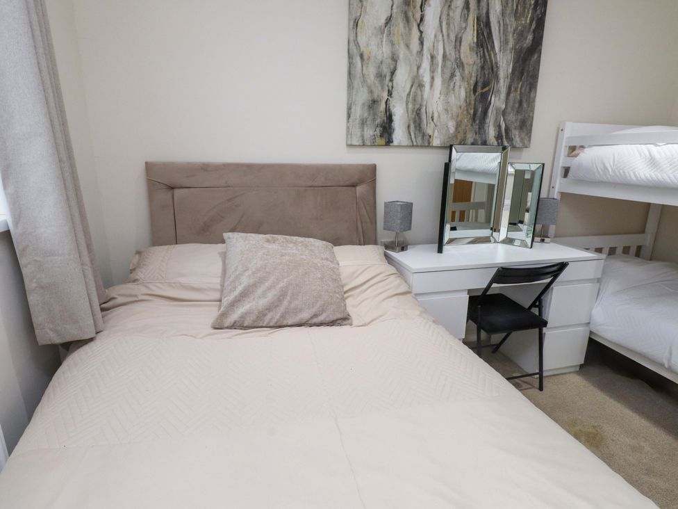 A bedroom with a bed and desk at Y Byngalo in Trearddur Bay