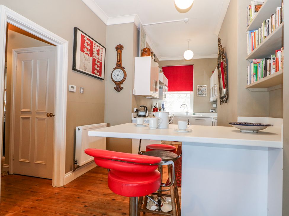 A kitchen with a table and stools at Broadstairs Beach in Broadstairs