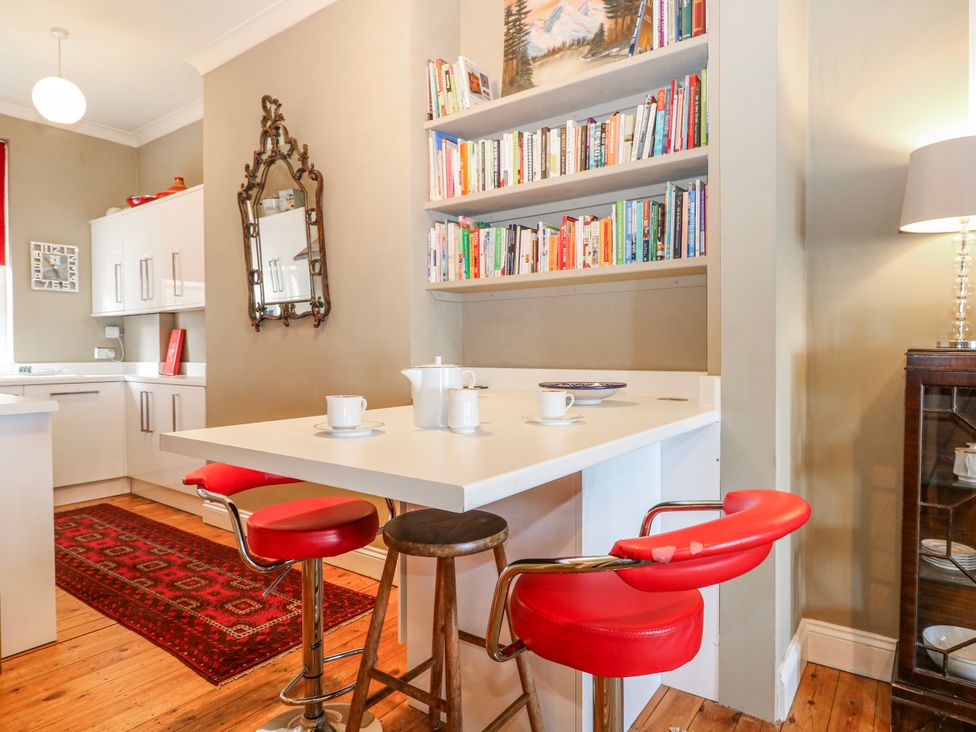 A kitchen with a table and bar stools at Broadstairs Beach in Broadstairs