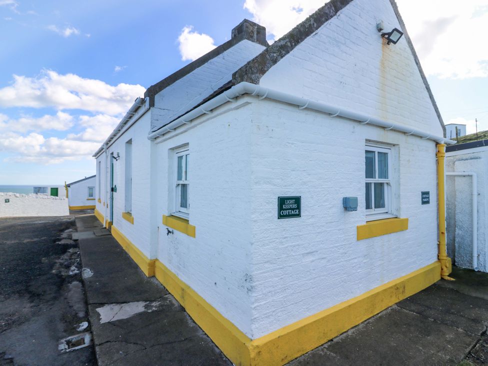 An exterior view of a cottage with a sign at The Lighthouse Keepers Cottage St Abbs