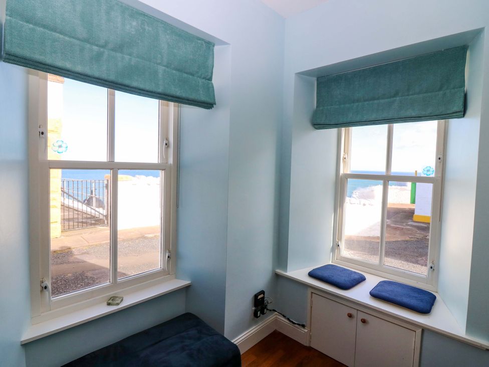 A sitting room with windows overlooking the sea at The Lighthouse Keepers Cottage St Abbs