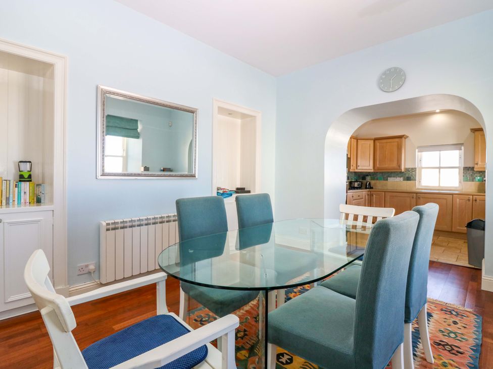 A dining room with a glass table and chairs at The Lighthouse Keepers Cottage St Abbs