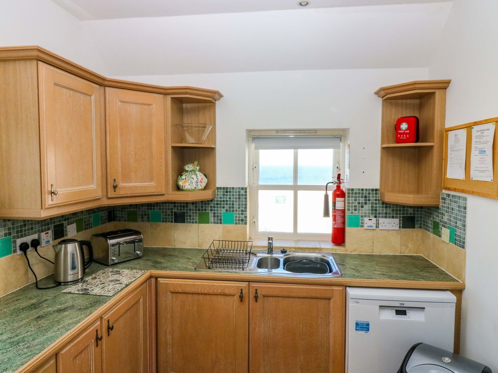 A kitchen with cabinets and sink at The Lighthouse Keepers Cottage St Abbs