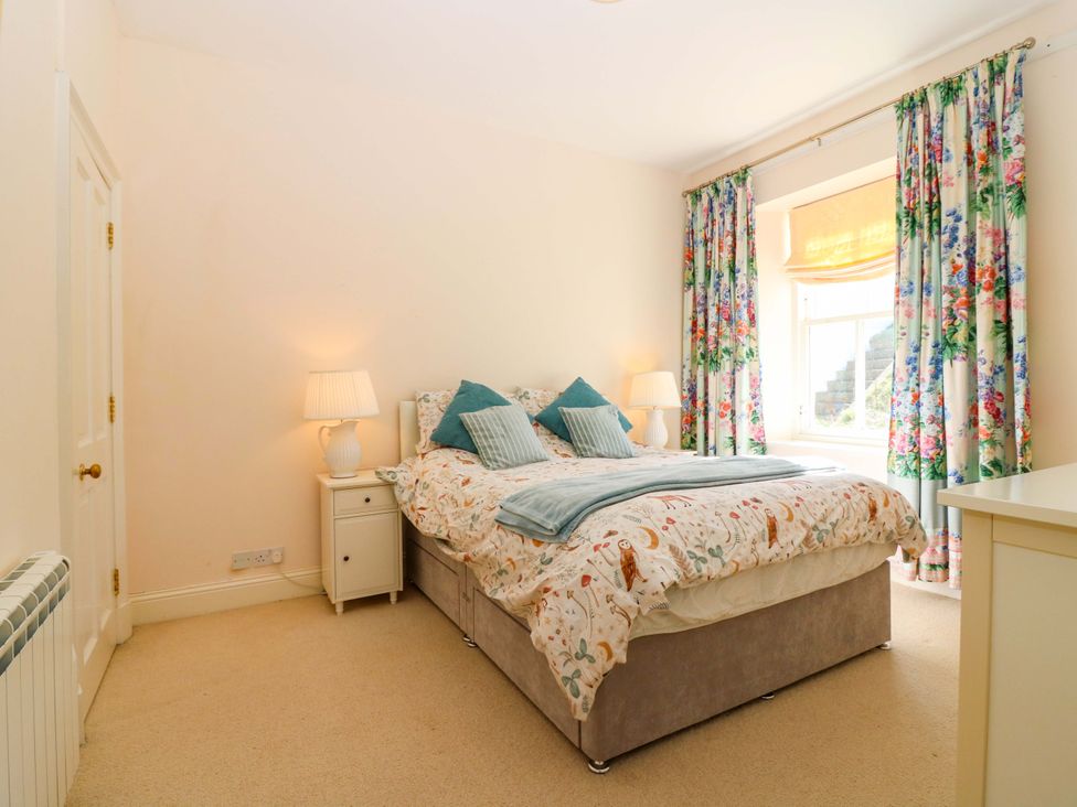 A bedroom with a bed and bedside table at The Lighthouse Keepers Cottage in St Abbs