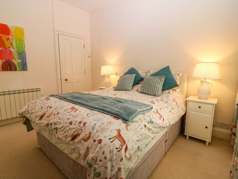 A bedroom with a bed and bedside tables at The Lighthouse Keepers Cottage St Abbs