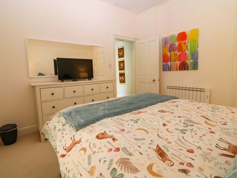A bedroom with a bed and dresser at The Lighthouse Keepers Cottage in St Abbs