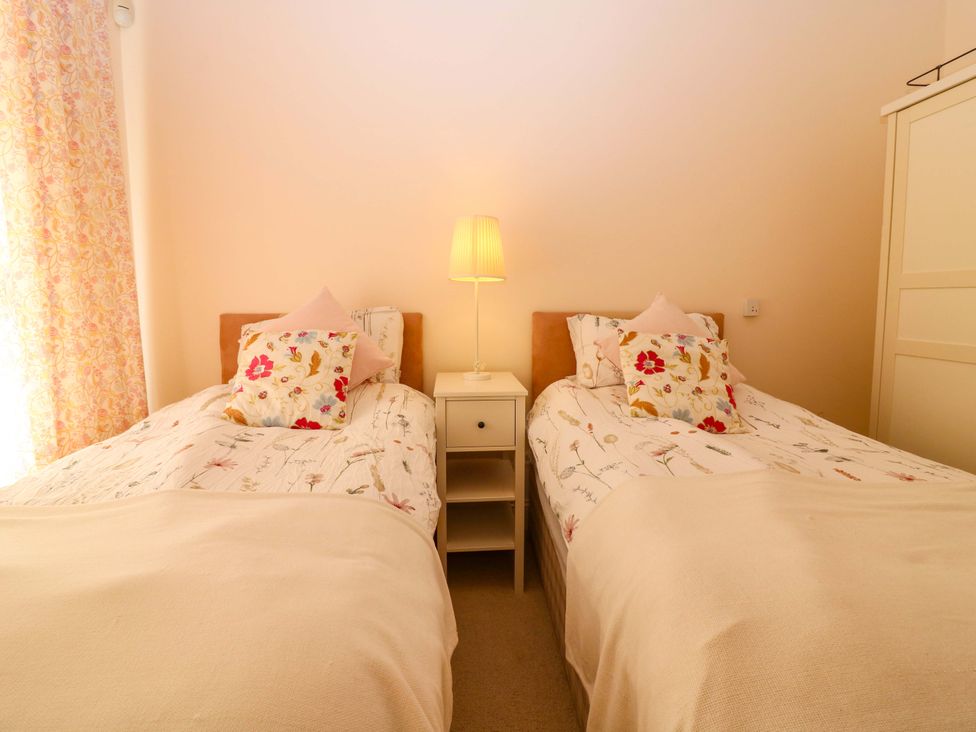 A bedroom with two single beds and a nightstand at The Lighthouse Keepers Cottage in St Abbs