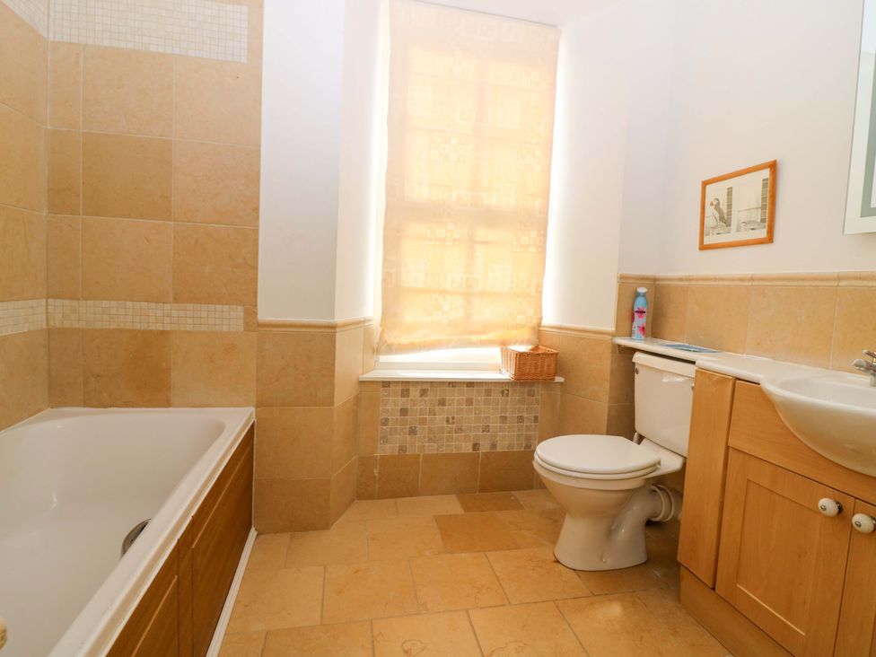 A bathroom with a bathtub, toilet, and sink at The Lighthouse Keepers Cottage in St Abbs