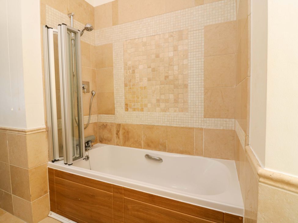 A bathroom with a bathtub and shower at The Lighthouse Keepers Cottage St Abbs
