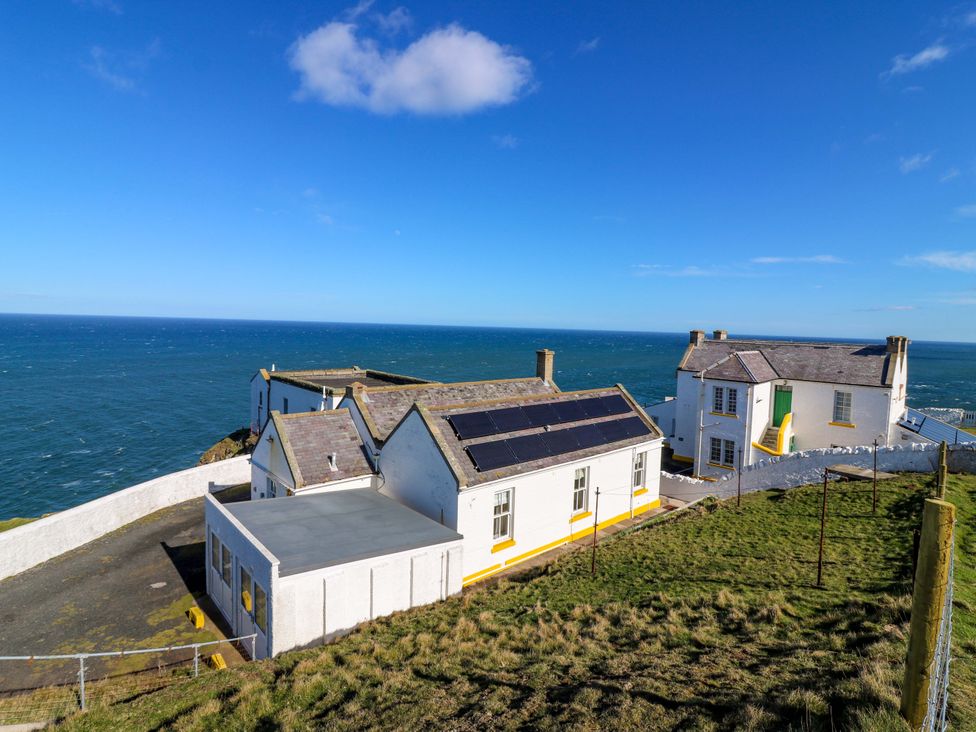 A house near the ocean with a grassy area at The Lighthouse Keepers Cottage in St Abbs
