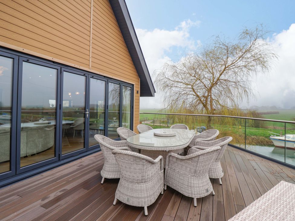 An outdoor patio with a table and chairs at Swing Bridge Cottage