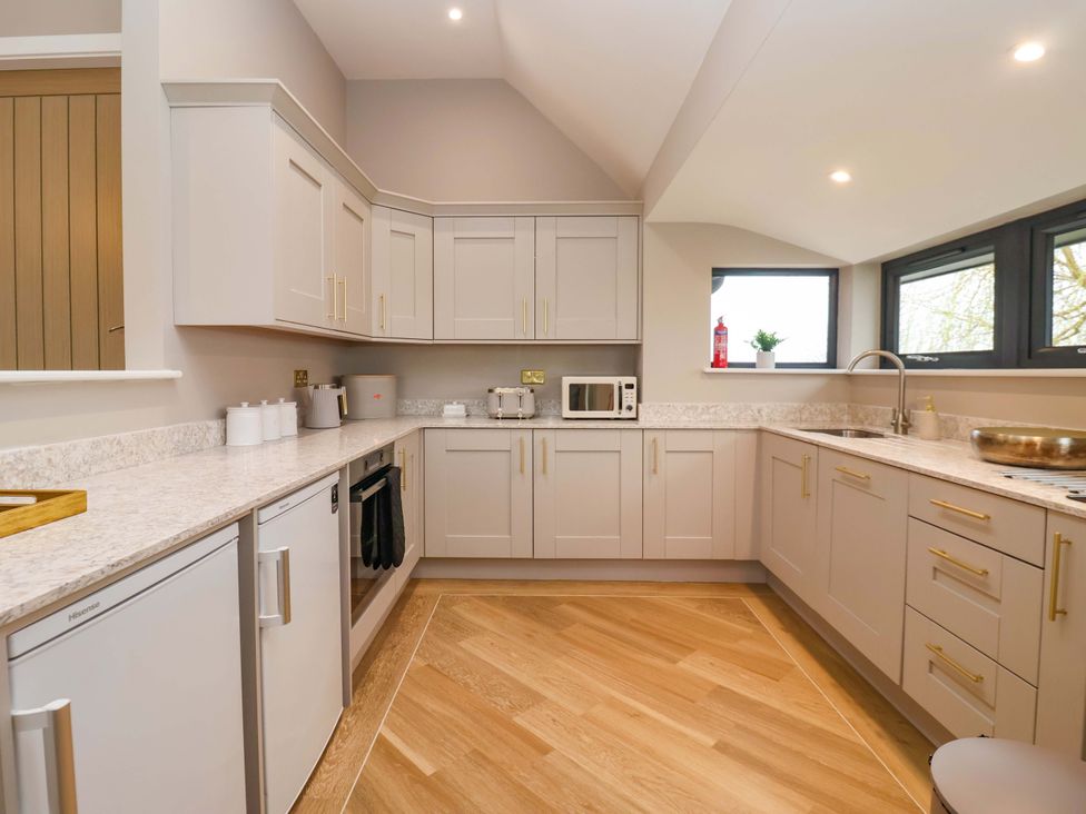 A kitchen with cabinets and appliances at Swing Bridge Cottage