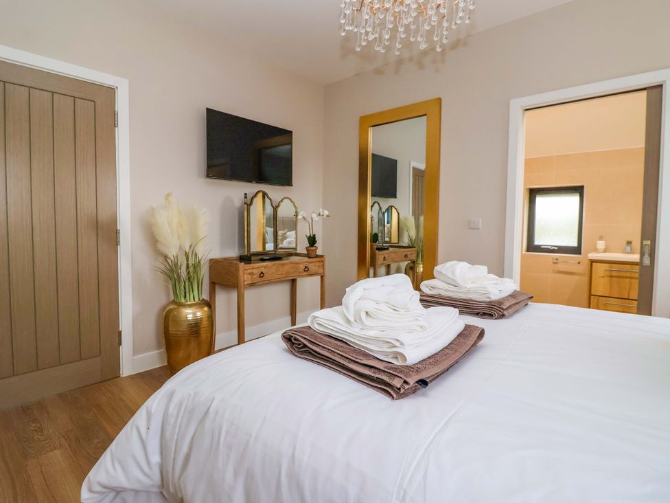 A bedroom with a bed and towels on top at Swing Bridge Cottage