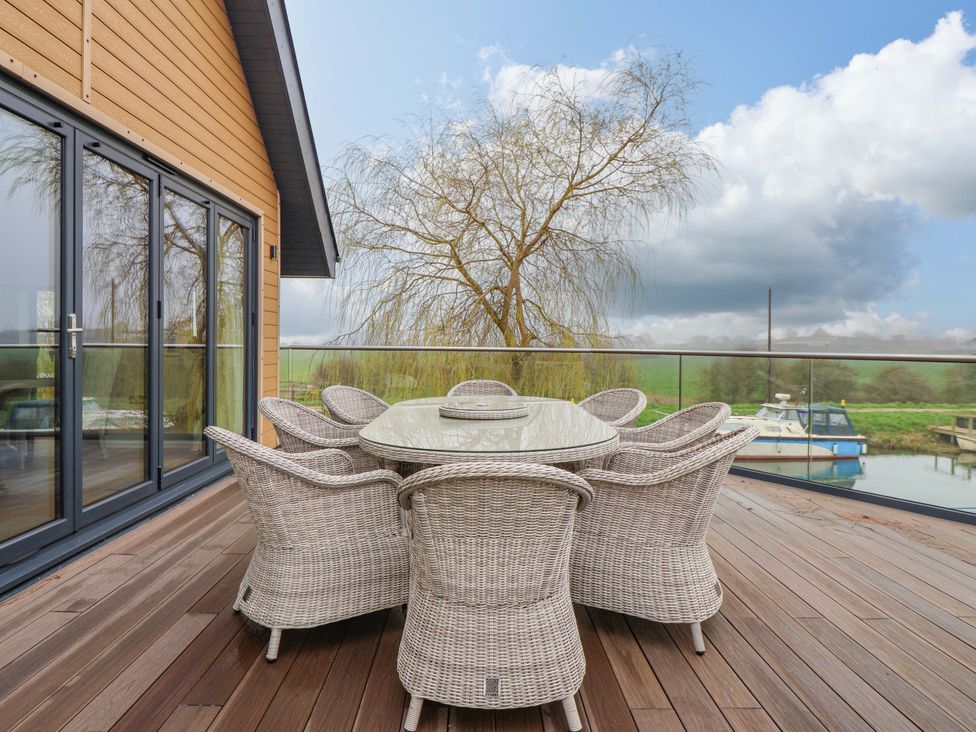 An outdoor patio with a table and chairs at Swing Bridge Cottage