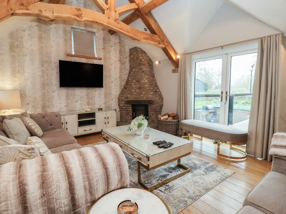 A living room with a fireplace and television at Mill Race Cottage Driffield