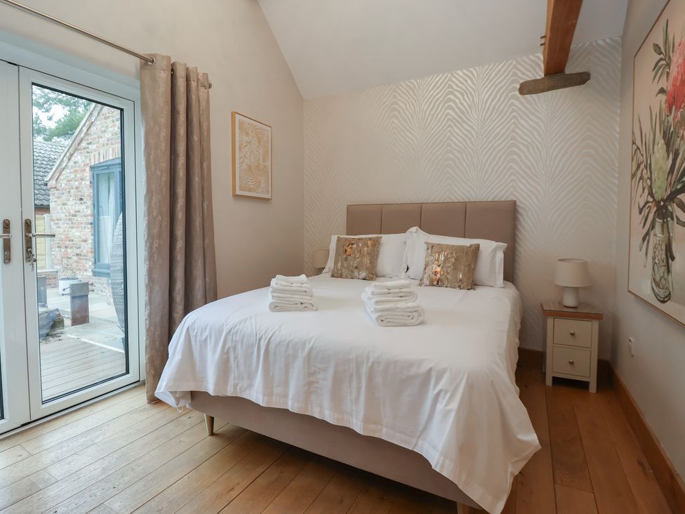 A bedroom with a bed and decor at Mill Race Cottage in Driffield