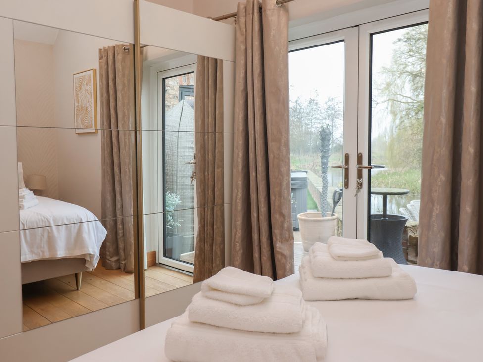 A bedroom with a bed and towels on the bed at Mill Race Cottage in Driffield