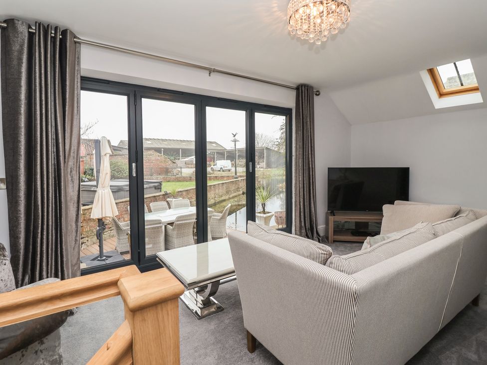 A living room with a sofa and television at Mill Race Cottage in Driffield