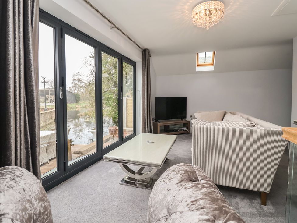 A living room with a television and a coffee table at Mill Race Cottage, Driffield
