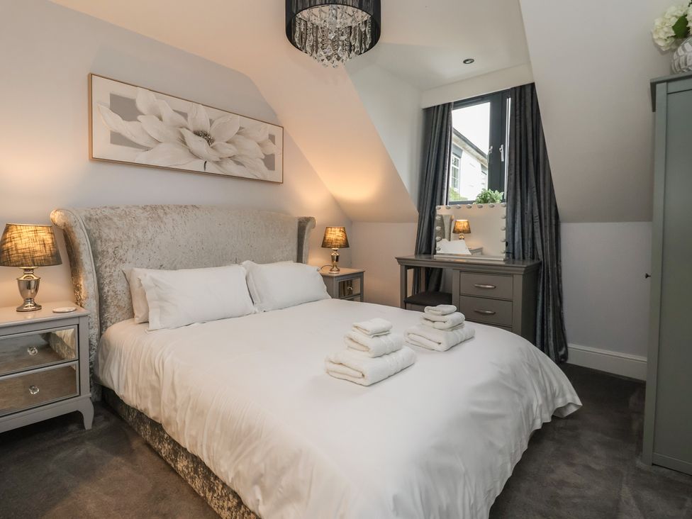 A bedroom with a bed and bedside tables at Mill Race Cottage Driffield